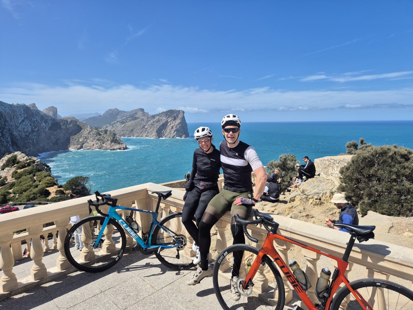 Two cyclists at a Mediterranean mountain viewpoint