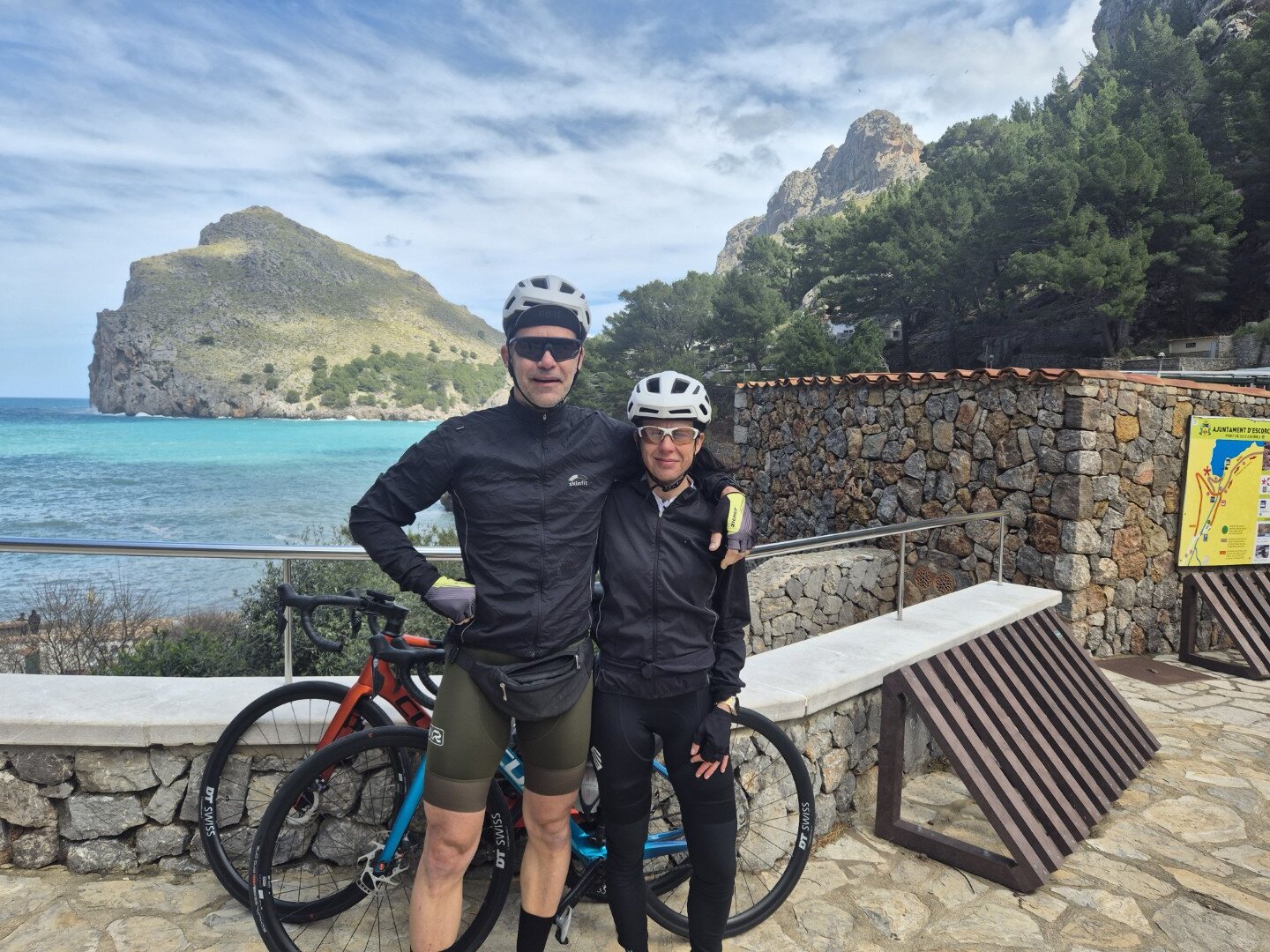 Two cyclists resting beside a mountain lake