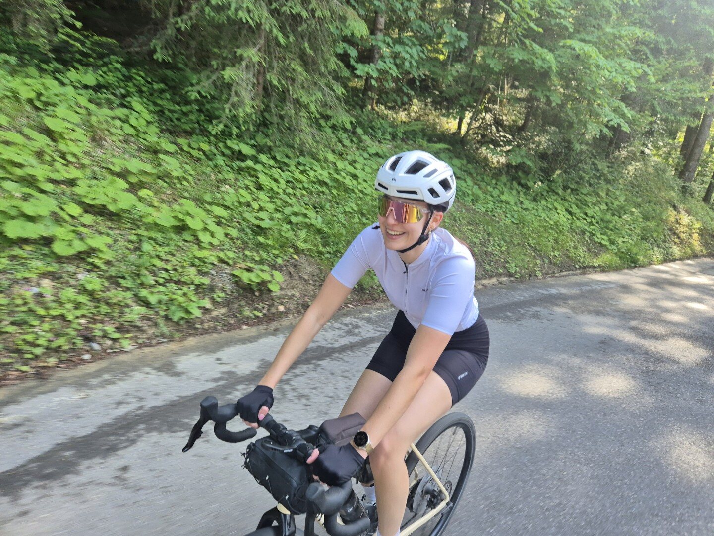 Cyclist riding on a shaded forest road