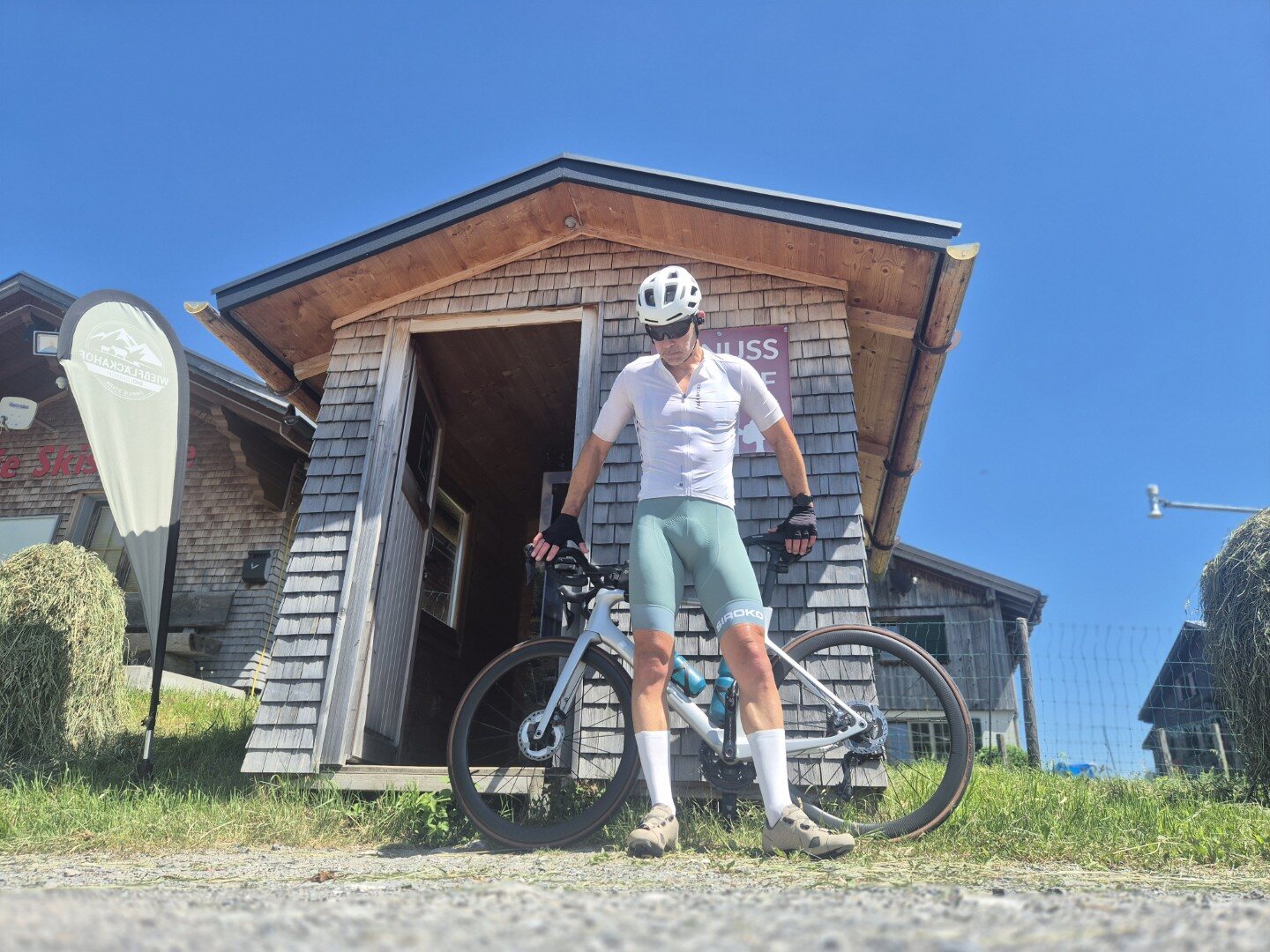 Cyclist with a bike outside an alpine hut